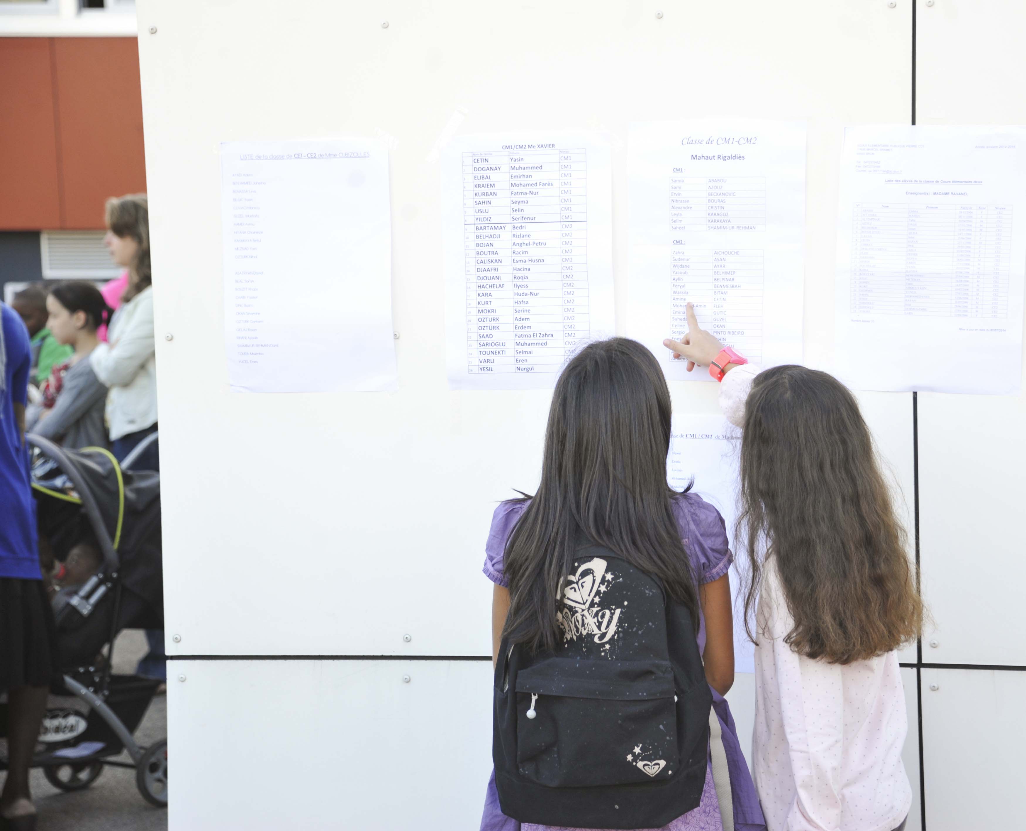 Deux enfants devant les listes à la rentrée scolaire