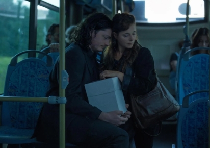 Phtotogramme issu du film "Mon inséparable". Dans un bus, une femme assise tient dans ses bras son fils adulte qui porte une boite blanche. Ils semblent indifférents au monde qui les entourent, comme dans une bulle.