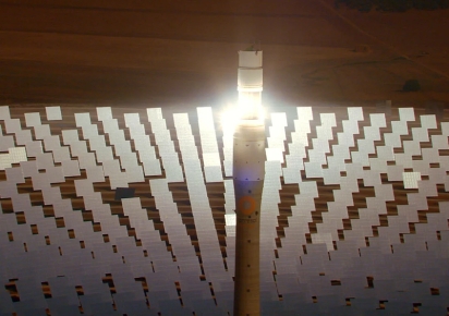 Photogramme issu du film Le Compte à rebours avec une vue de haut d'une centrale solaire avec des panneaux solaires disposés en arc de cercle autour d'une immense tour technique.